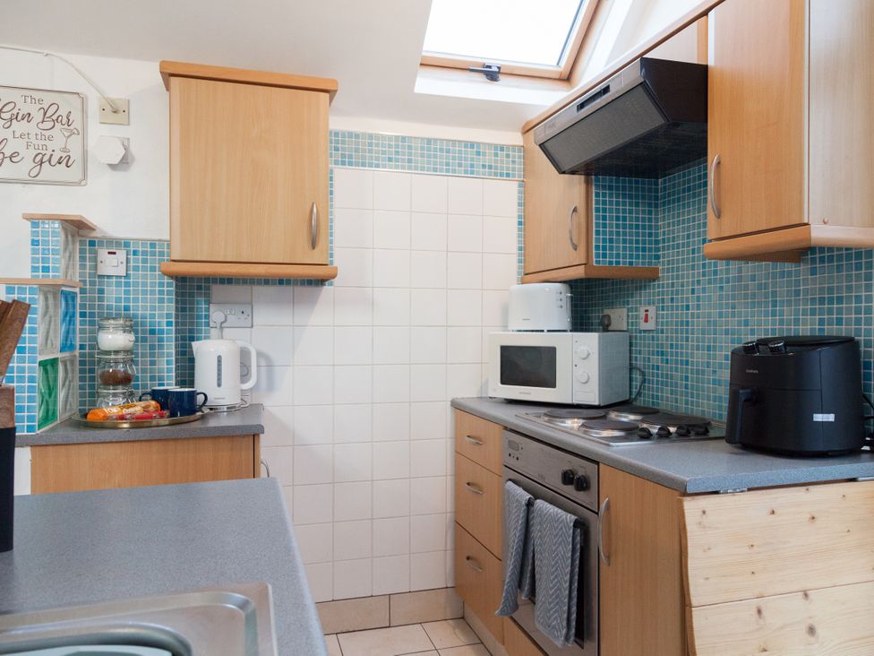 A kitchen with cabinets and appliances at 4 Kingscliffe Street in Manchester