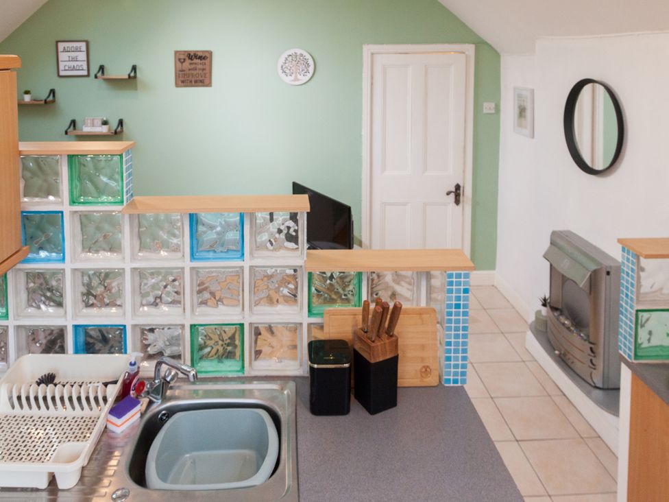 A kitchen with a sink and kitchen utensils at 4 Kingscliffe Street, Manchester