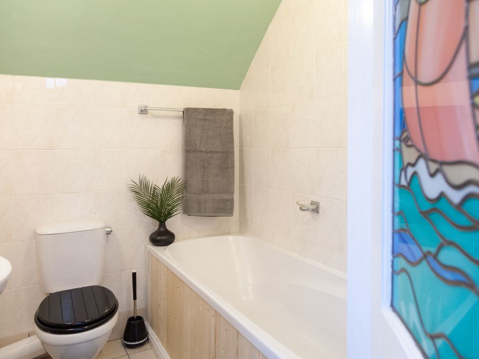 A bathroom with a bathtub and toilet at 4 Kingscliffe Street in Manchester