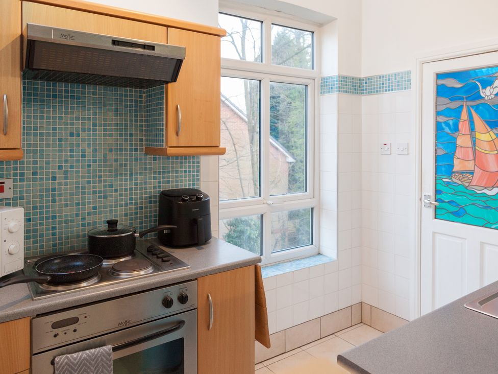 A kitchen with a stove, kettle, and window at 4 Kingscliffe Street in Manchester