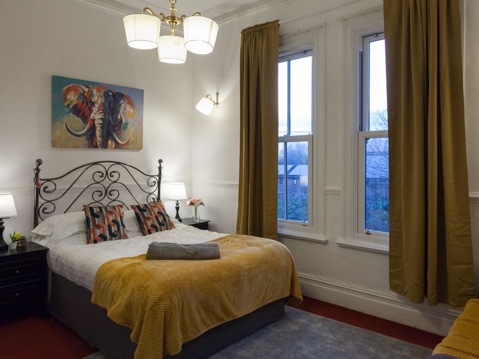 A bedroom with a bed and windows at 4 Kingscliffe Street Manchester