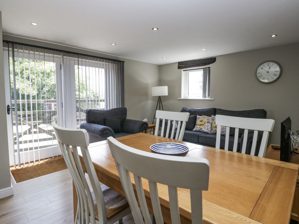 A dining room with a table and sofas at Threagill in Carnforth