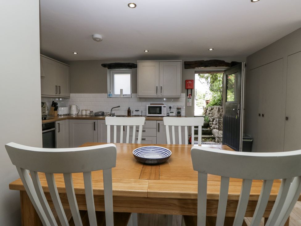 A kitchen with cabinets and table at Threagill in Carnforth