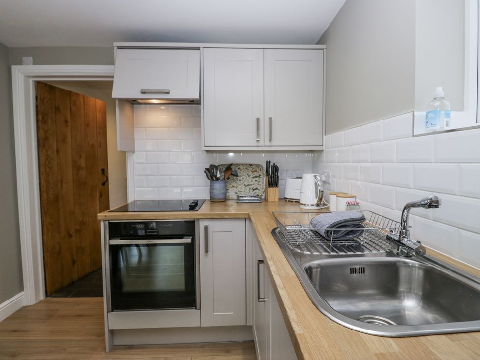 A kitchen with a sink, countertop, and oven at Threagill in Carnforth