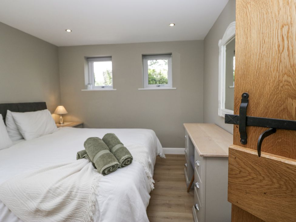 A bedroom with a bed and dresser at Threagill in Carnforth