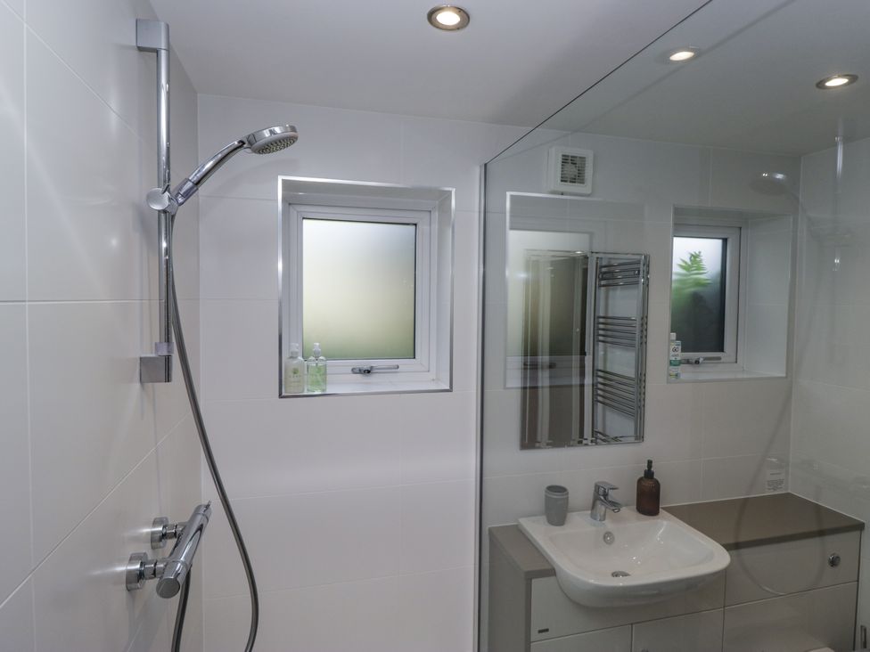 A bathroom with a shower and sink at Threagill in Carnforth