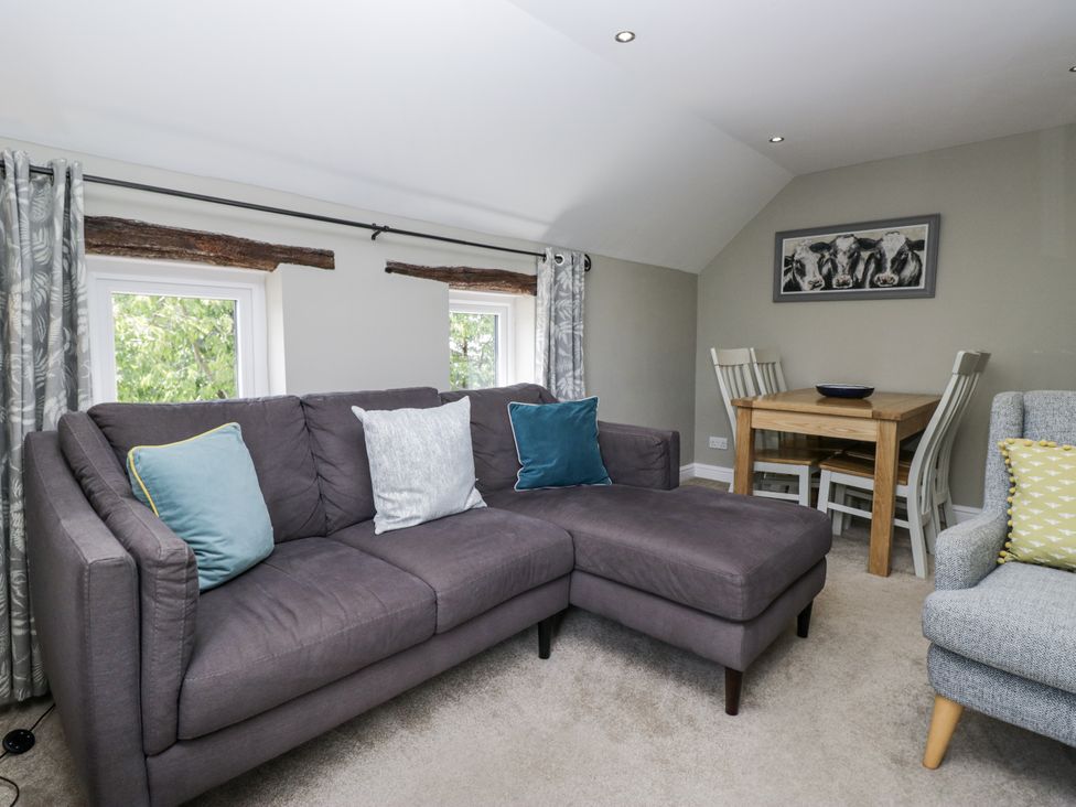 A living room with a sofa and dining area at Treacle in Carnforth