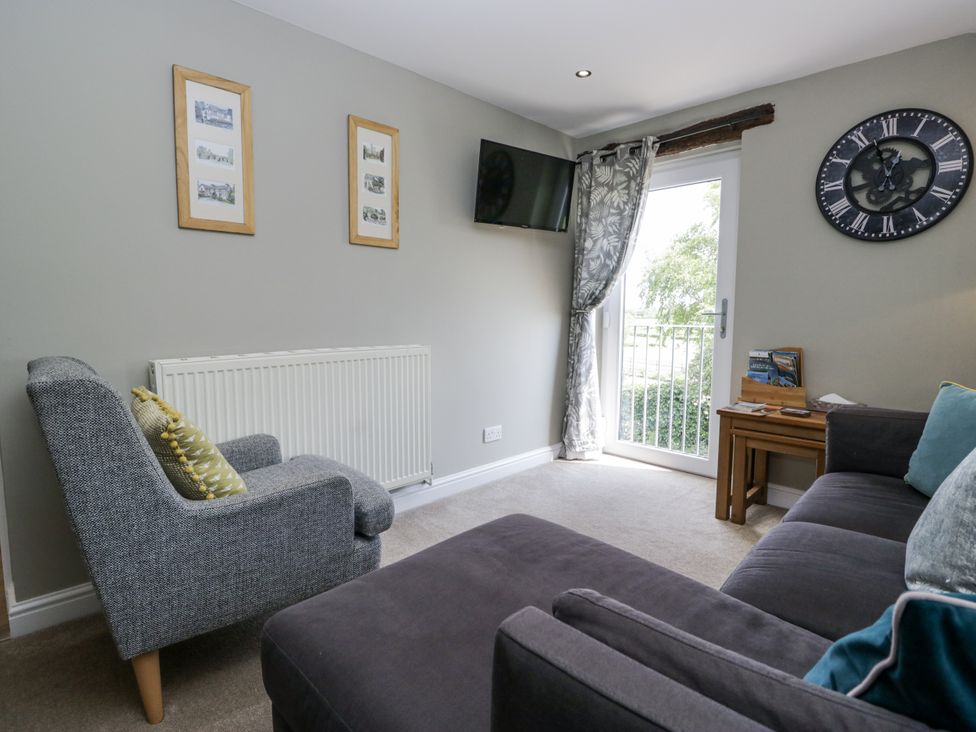 A living room with a sofa and armchair at Treacle in Carnforth