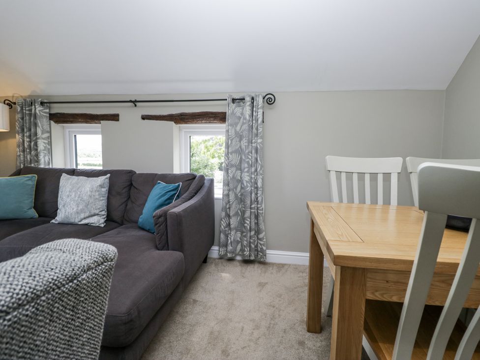 A snug with a sofa and a dining table at Treacle in Carnforth