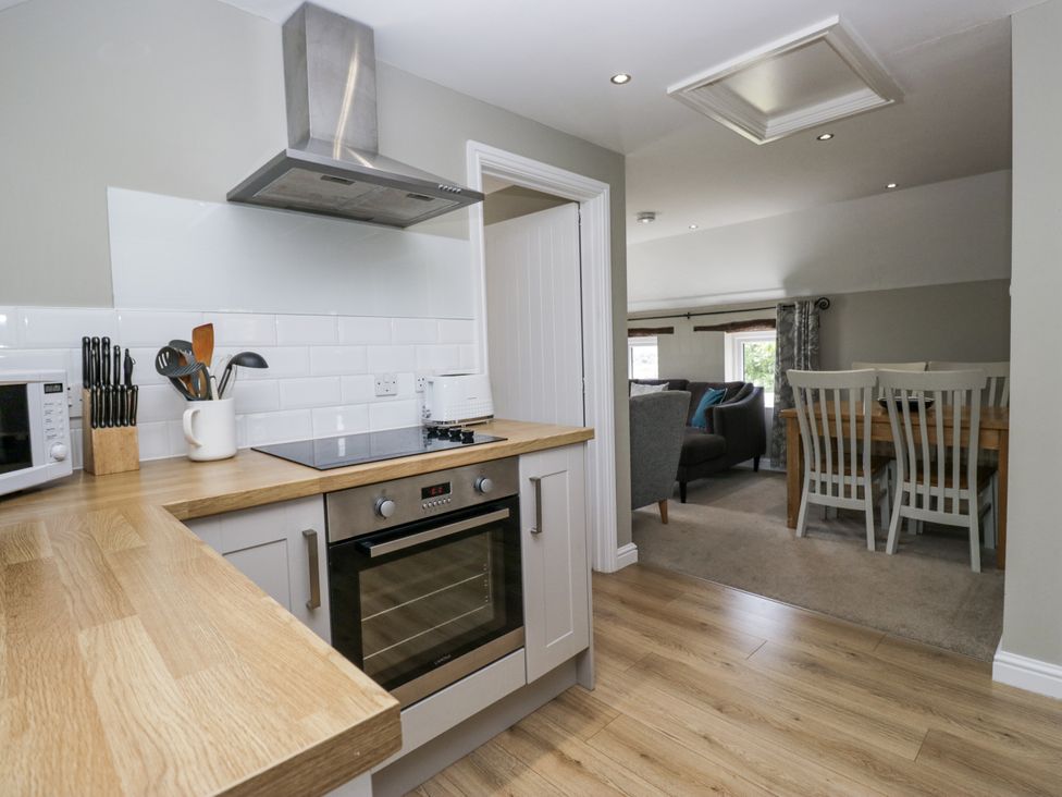 A kitchen with appliances and a view to the dining area at Treacle in Carnforth