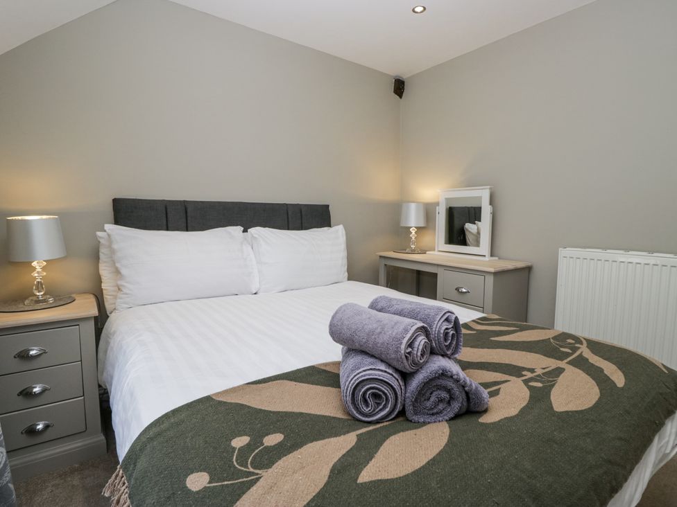 A bedroom with a bed and towels at Treacle in Carnforth