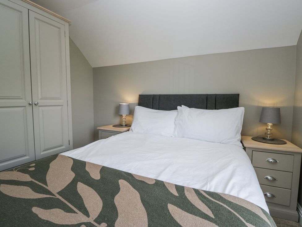 A bedroom with a bed and nightstand at Treacle in Carnforth
