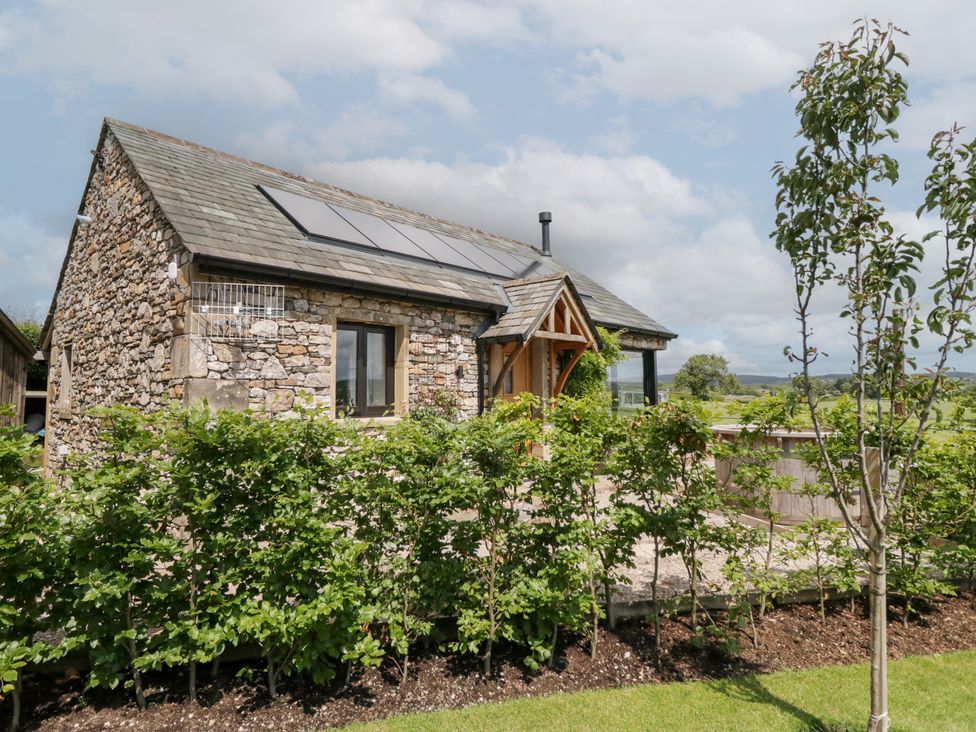 A stone house with solar panels and plants at Lindeth Croft in Carnforth