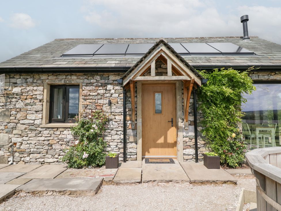 An entrance with a wooden door and stone walls at Lindeth Croft in Carnforth