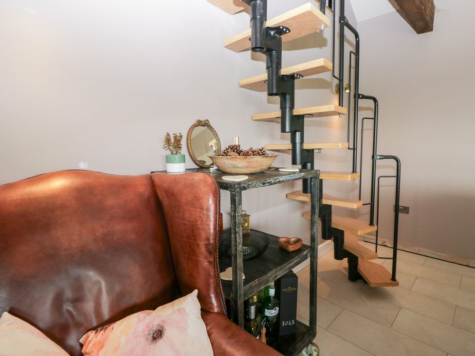 A living room with a sofa and staircase at Lindeth Croft in Carnforth