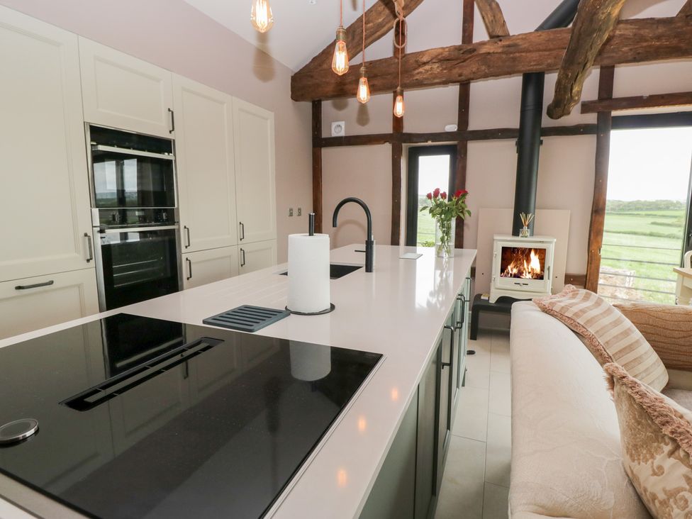 A kitchen with a countertop, stove, and fireplace at Lindeth Croft in Carnforth
