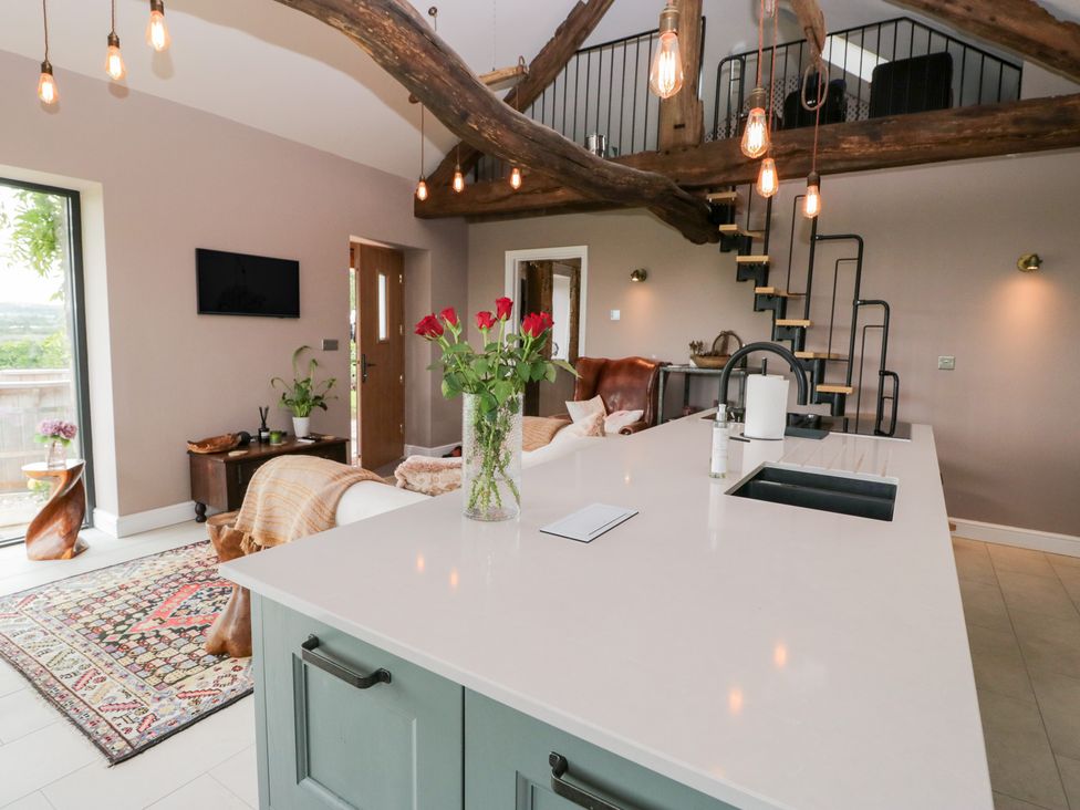 A living room with a kitchen island and sofa at Lindeth Croft in Carnforth
