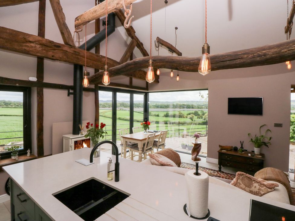 A kitchen with a dining area and large windows at Lindeth Croft in Carnforth