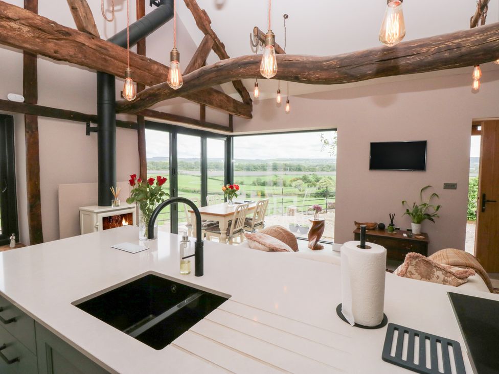 A kitchen with a sink, stove, and dining area at Lindeth Croft in Carnforth
