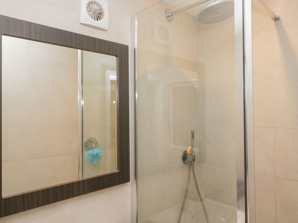 A bathroom with a shower and mirror at Lindeth Croft in Carnforth