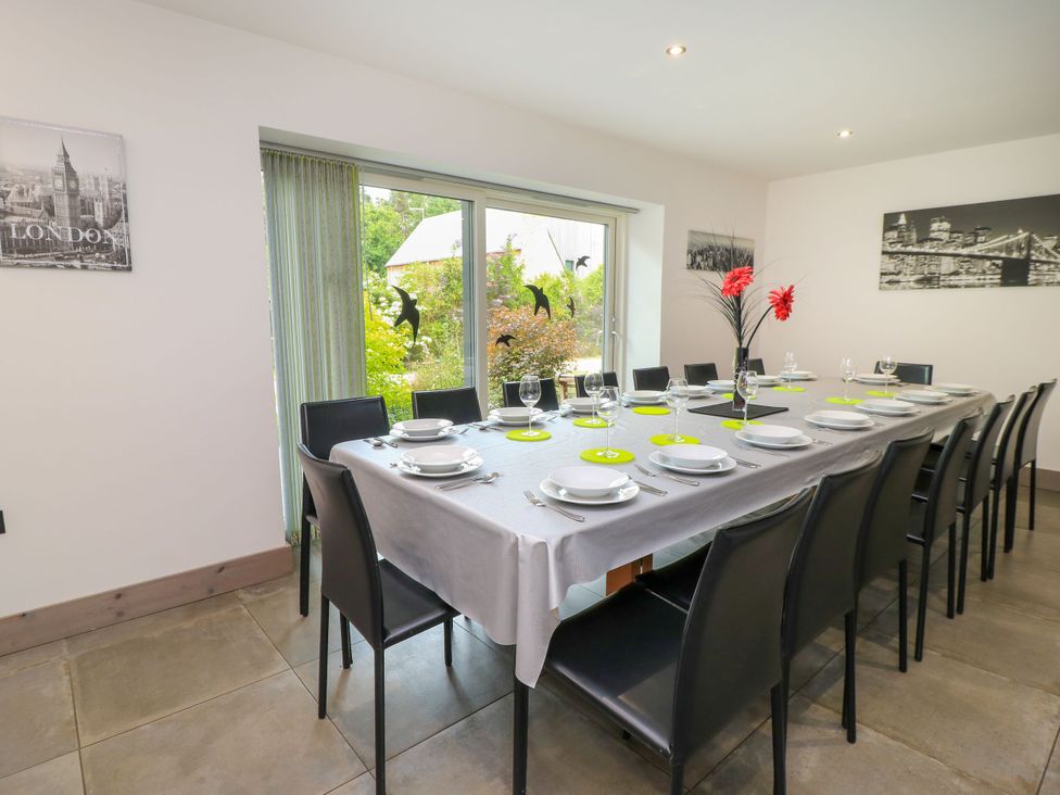 A dining room with a long table and chairs at Silver Copse in Frilford Heath Near Abingdon