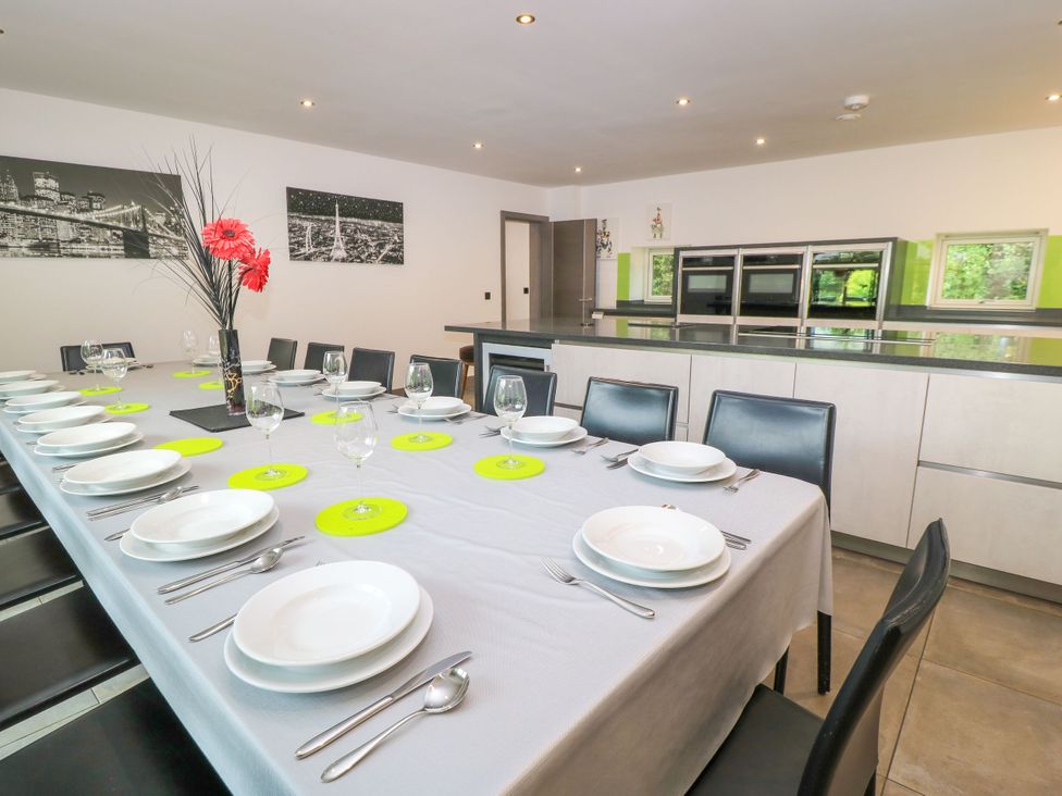 A dining room with a long table set for a meal at Silver Copse Frilford Heath Near Abingdon