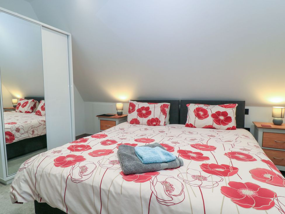 A bedroom with a bed and bedside tables at Silver Copse in Frilford Heath Near Abingdon