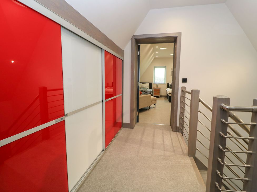 A hallway with a sliding wardrobe and door at Silver Copse Frilford Heath Near Abingdon