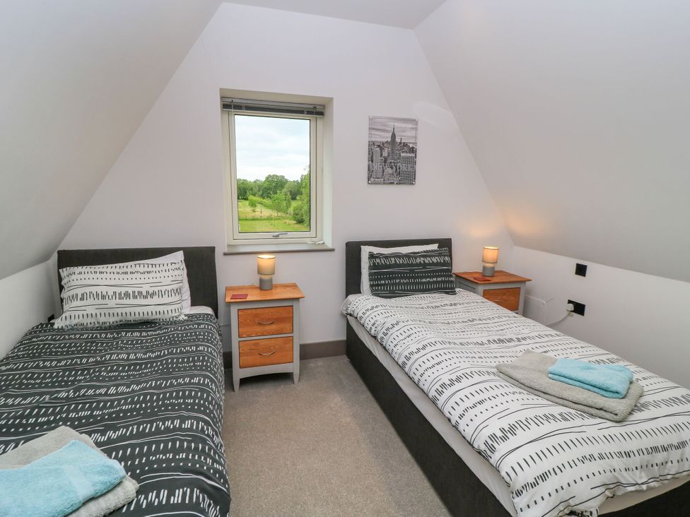 A bedroom with two beds and a window at Silver Copse Frilford Heath Near Abingdon