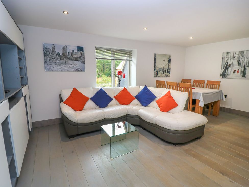 A living room with a sectional sofa and dining table at Silver Copse Frilford Heath Near Abingdon