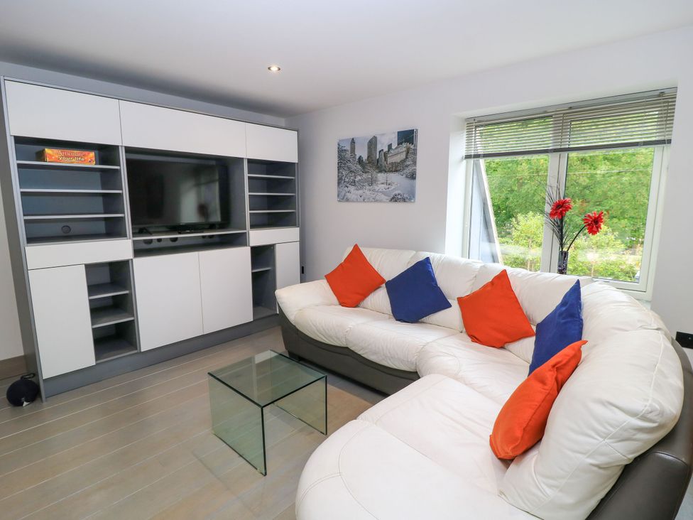 A living room with a sectional sofa and television unit at Silver Copse in Frilford Heath Near Abingdon