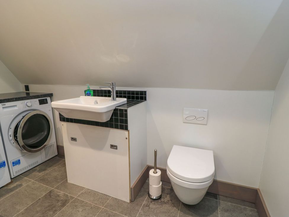 A bathroom with a washing machine, sink, and toilet at Silver Copse Frilford Heath Near Abingdon