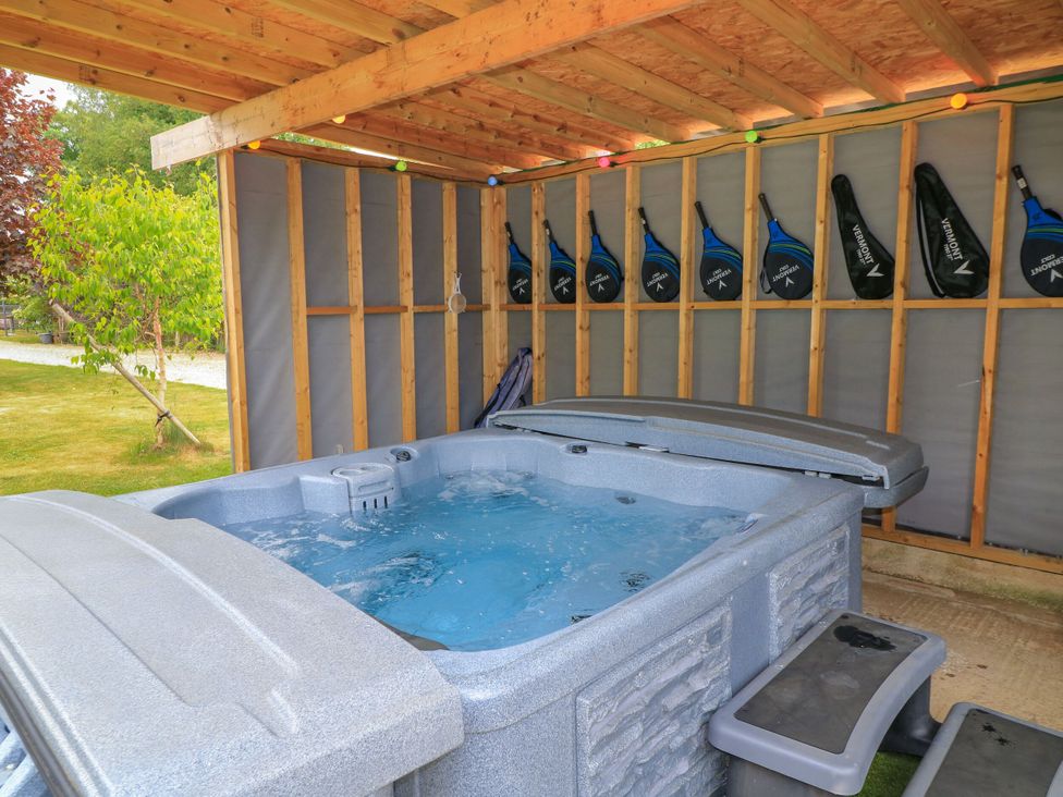 A hot tub surrounded by wooden beams and paddles at Silver Copse in Frilford Heath Near Abingdon