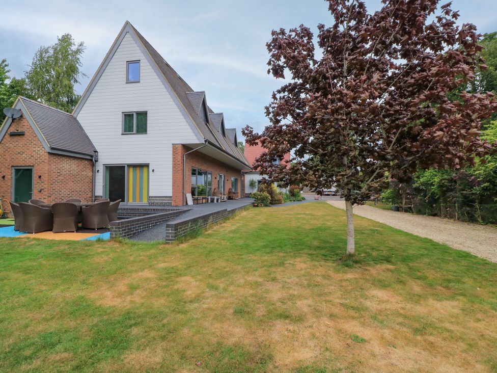 An outdoor area with a house and chairs in the garden at Silver Copse Frilford Heath Near Abingdon