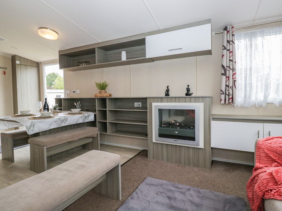 A living room with a dining table and fireplace at Heathfield Park S4