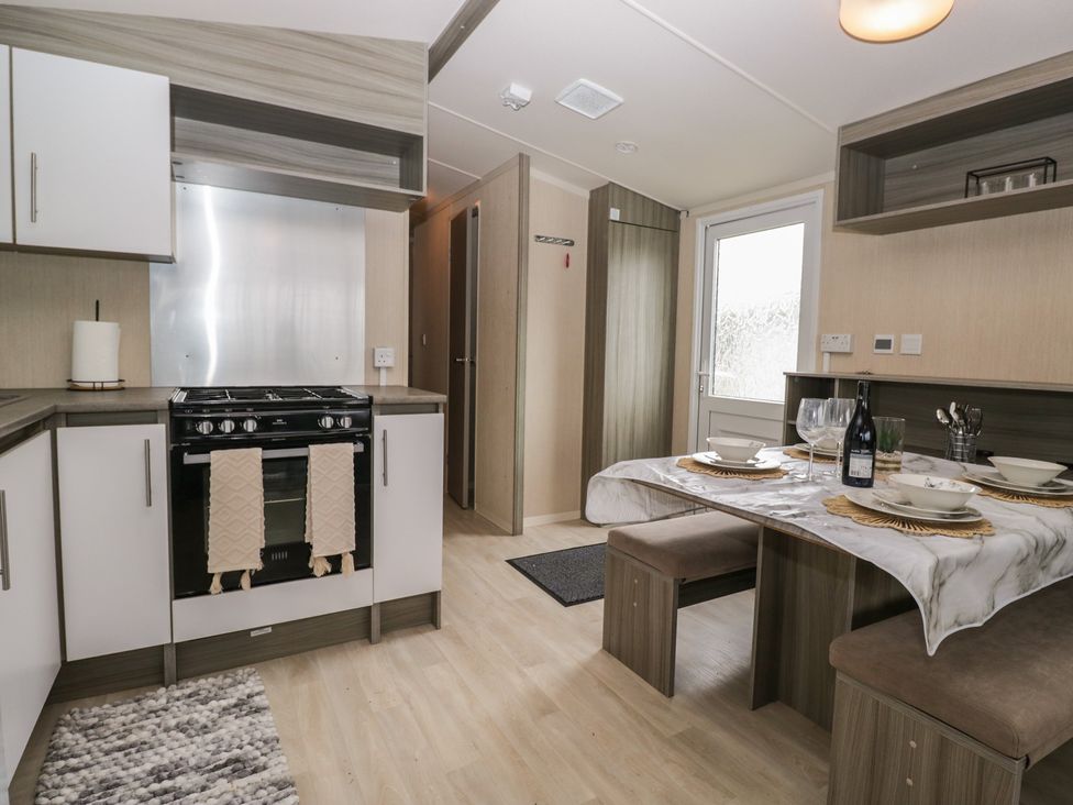 A kitchen with stove and dining table at Heathfield Park S4