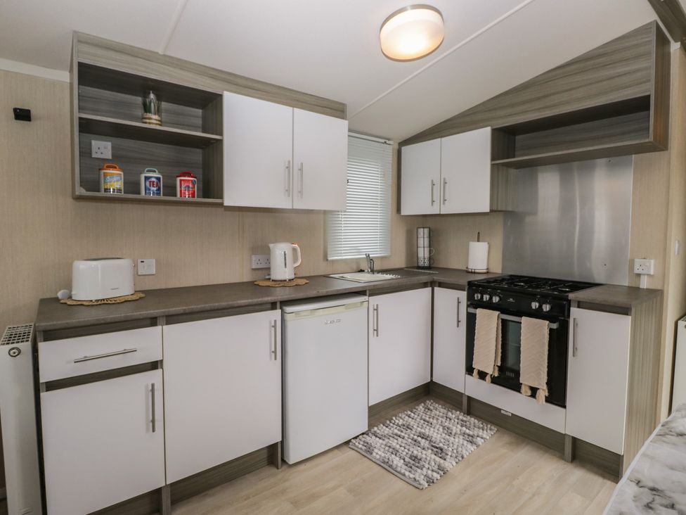 A kitchen with cabinets and appliances at Heathfield Park S4