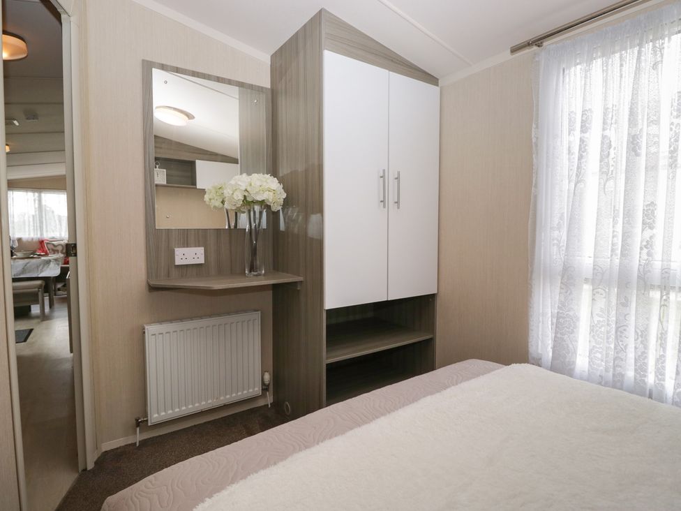 A bedroom with a bed and wardrobe at Heathfield Park S4