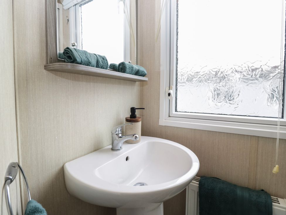 A bathroom with a sink and mirror at Heathfield Park S4