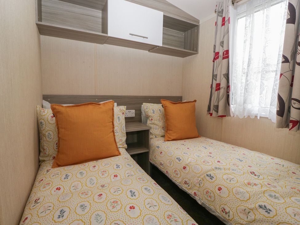 A bedroom with two beds and shelves at Heathfield Park S4