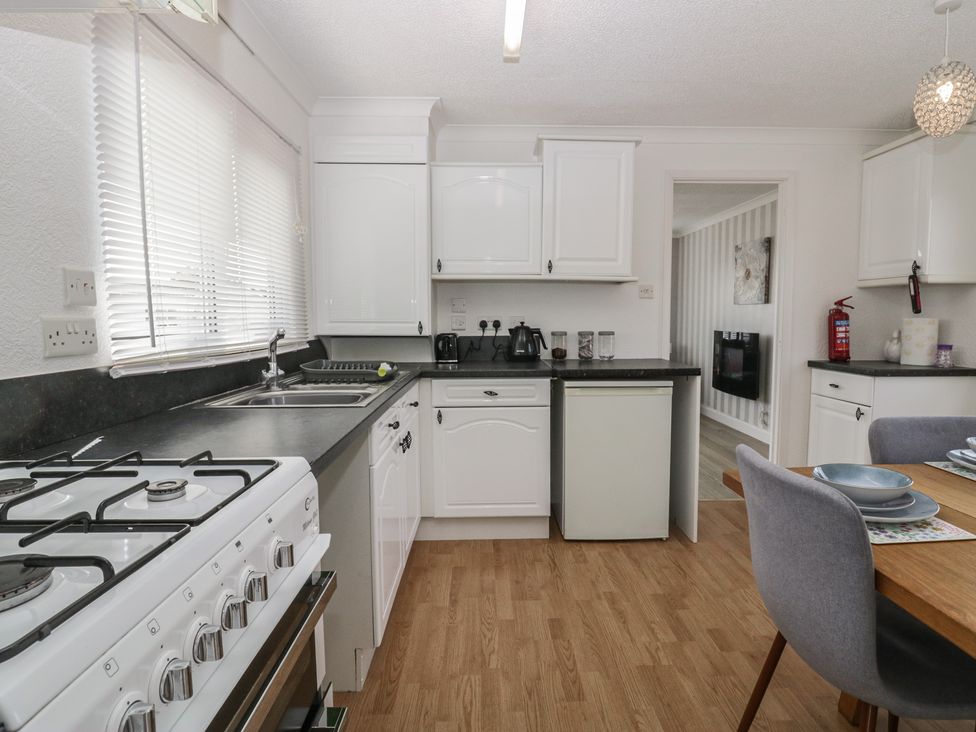 A kitchen with a gas stove and refrigerator at Cherry Tree in Kidlington