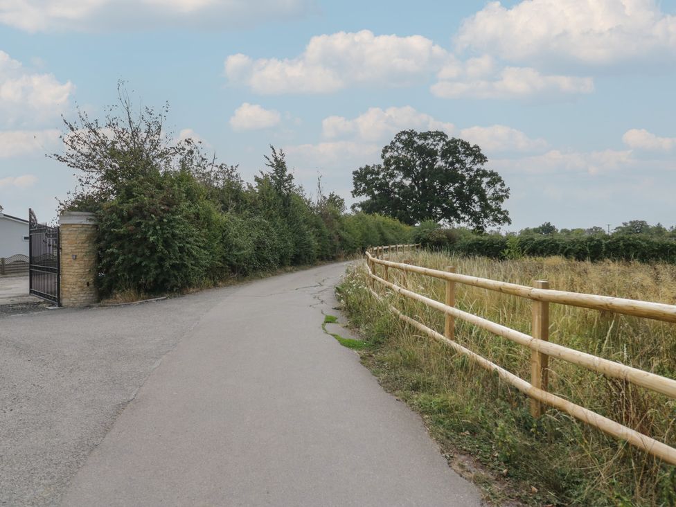 A road with a wooden fence and hedges at Cherry Tree in Kidlington