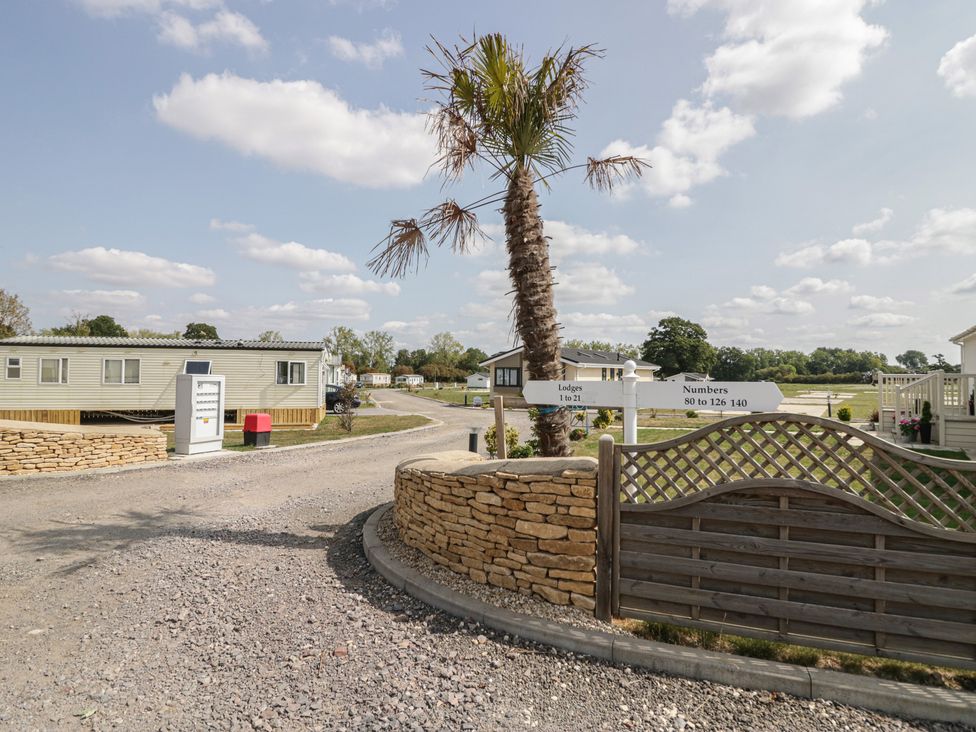 An outdoor area with caravans and a palm tree at Cherry Tree in Kidlington