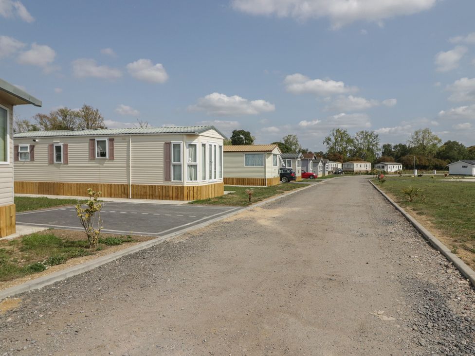 An outdoor area with mobile homes and a gravel road at Cherry Tree in Kidlington