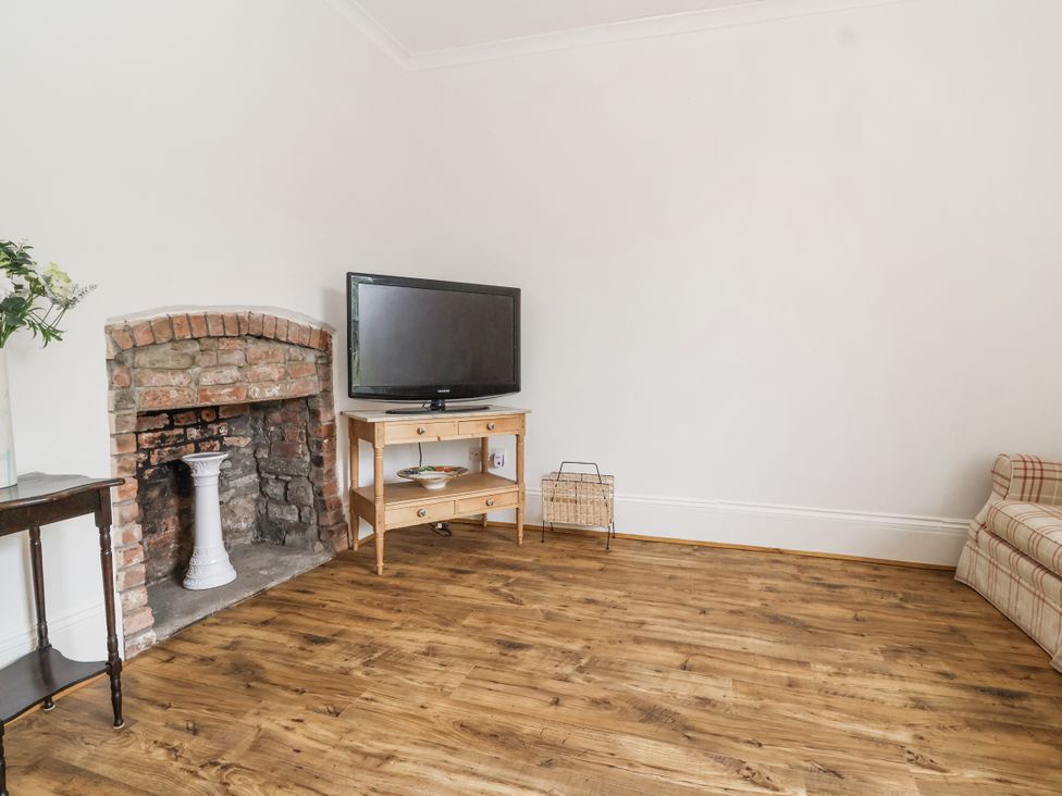 A living room with a television and fireplace at The Cottage in Clevedon