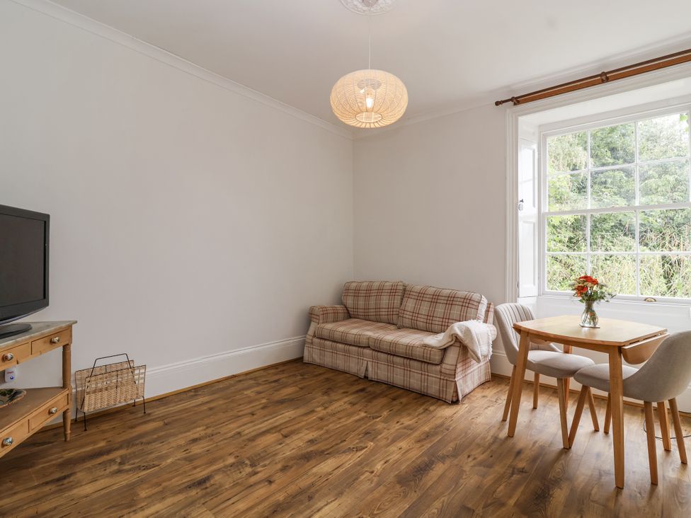 A living room with a sofa and dining table at The Cottage in Clevedon