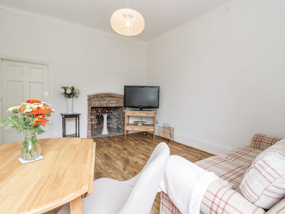 A living room with a sofa and television at The Cottage in Clevedon