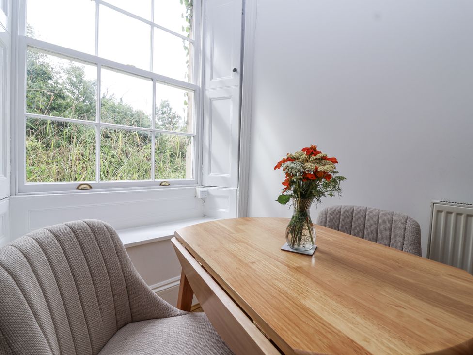 A dining room with a table and chairs at The Cottage in Clevedon