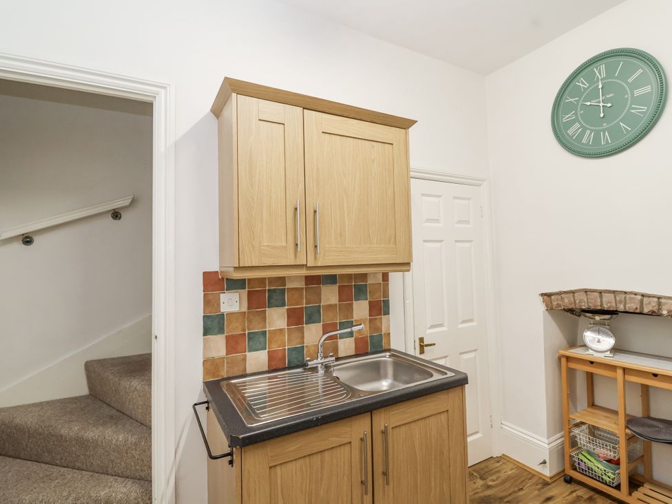 A kitchen with a sink and cupboard at The Cottage in Clevedon