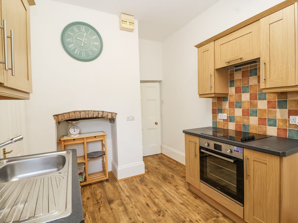 A kitchen with a clock and oven at The Cottage in Clevedon
